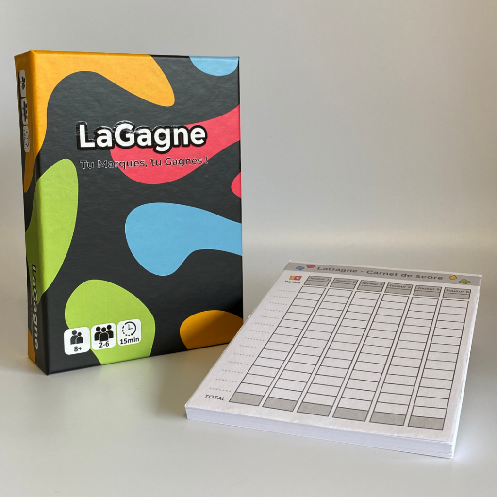 La photo montre le pack tournoi "LaGagne", comprenant un jeu de cartes et un bloc-note. Le jeu est placé à côté du bloc-note, prêt à être utilisé pour une partie de tournoi.